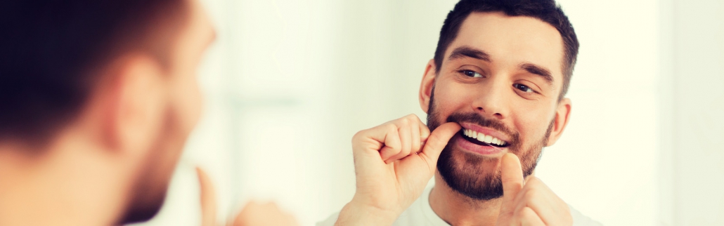 Man flossing with perfect teeth