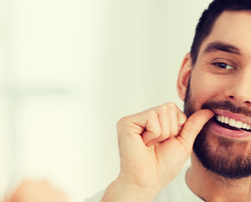 Man flossing with perfect teeth